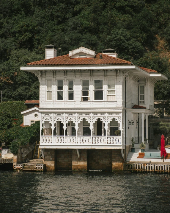 a white house sitting on top of a body of water, inspired by Fikret Muallâ Saygı, pexels contest winner, art nouveau, turkey, chalet, lush surroundings, thumbnail