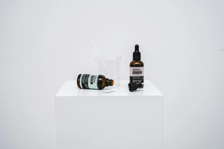 a bottle of cbd oil next to a bottle of cbd oil, unsplash, artforum aesthetic, in front of white back drop, on a pedestal, demna gvasalia