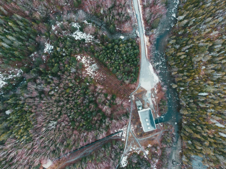 an aerial view of a road in the middle of a forest, an album cover, by Jaakko Mattila, pexels contest winner, hurufiyya, in an icy river, mining outpost, thumbnail, hd footage