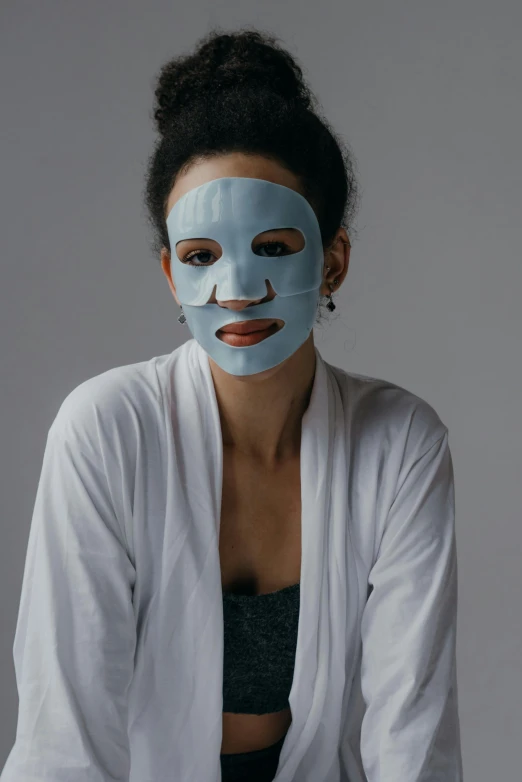 a woman with a blue mask on her face, grey, product shot, face shown, diverse