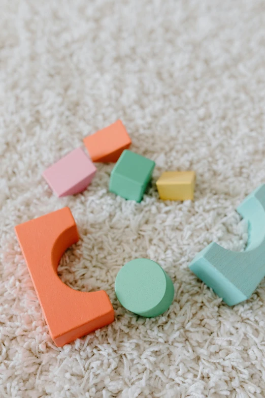 a close up of a toy on a carpet, inspired by Isamu Noguchi, unsplash, building blocks, multi pastel colors, square shapes, premium quality