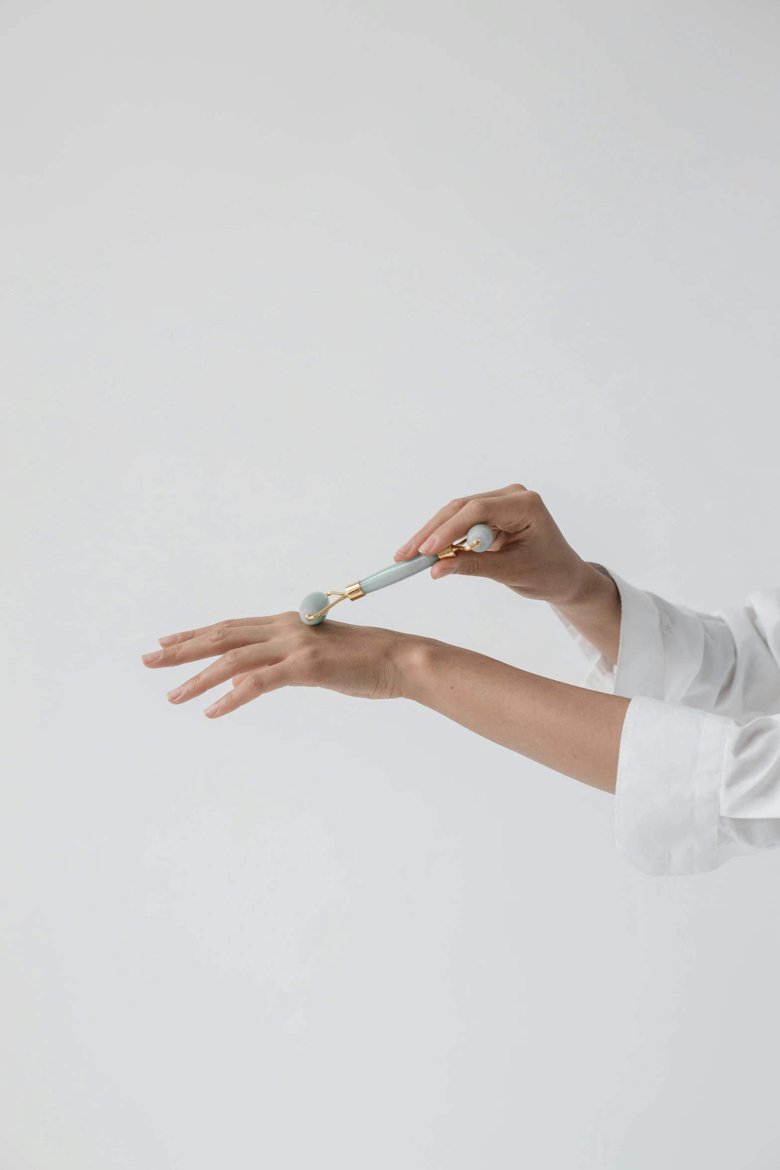 a woman in a white shirt holding a pair of scissors, inspired by Anna Füssli, unsplash, kinetic art, holding syringe, porcelain looking skin, clean white lab background, orrery