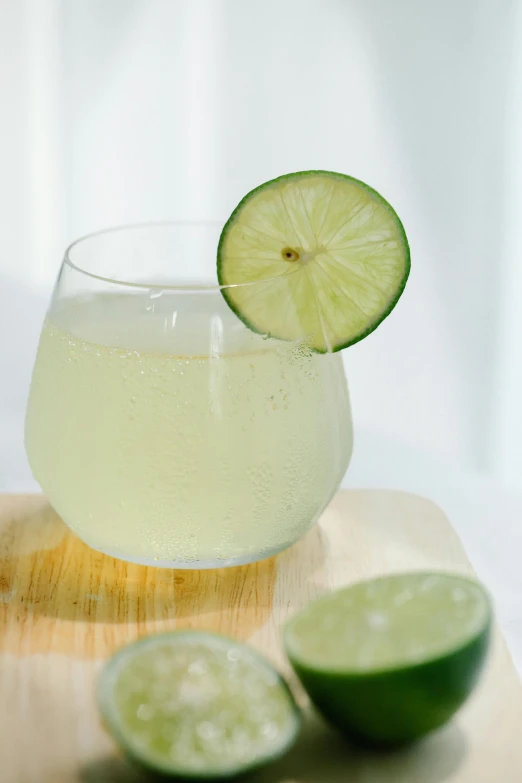 a glass of limeade sitting on top of a cutting board, renaissance, fine bubbles, made of glazed, fan favorite, laser