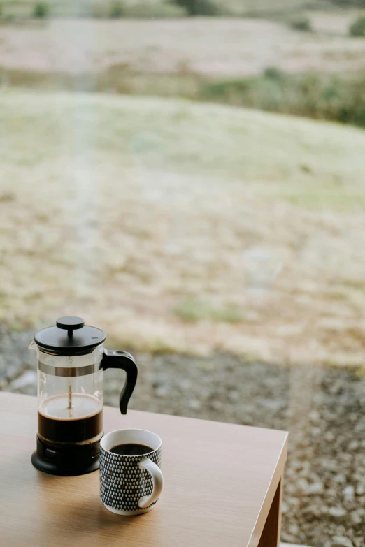 a coffee pot sitting on top of a wooden table, a picture, unsplash, natural light outside, gif, small, hero shot