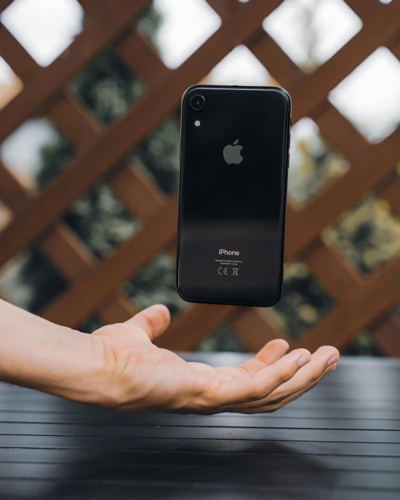 a person holding an iphone in their hand, unsplash contest winner, defying gravity, sharply shaped, 🚀🌈🤩, 3 / 4 pose