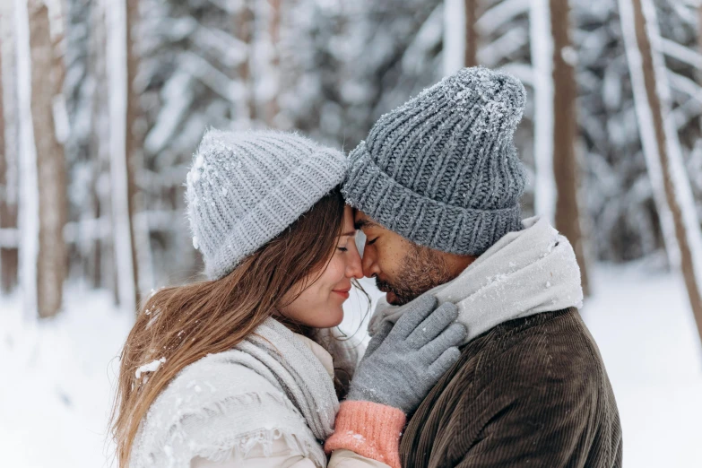 a man and woman standing next to each other in the snow, pexels contest winner, knitted hat, cuddling, avatar image, gray