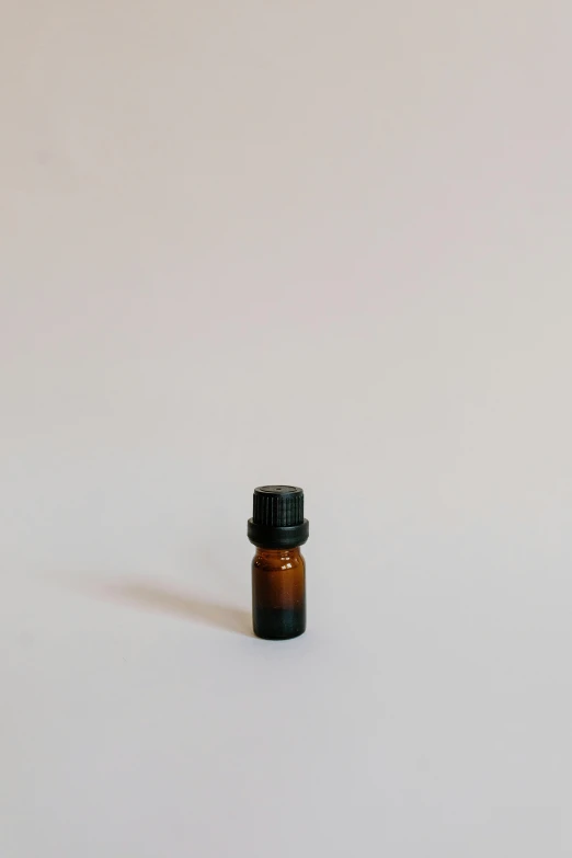 a bottle of essential oil on a white surface, by Gavin Hamilton, unsplash, visual art, ignant, 1 8 mm, brown, icon