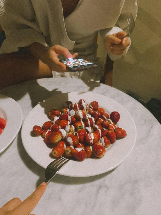 a woman taking a picture of a plate of strawberries, by Emma Andijewska, 😭🤮 💔, late night, milan jozing, whipped cream