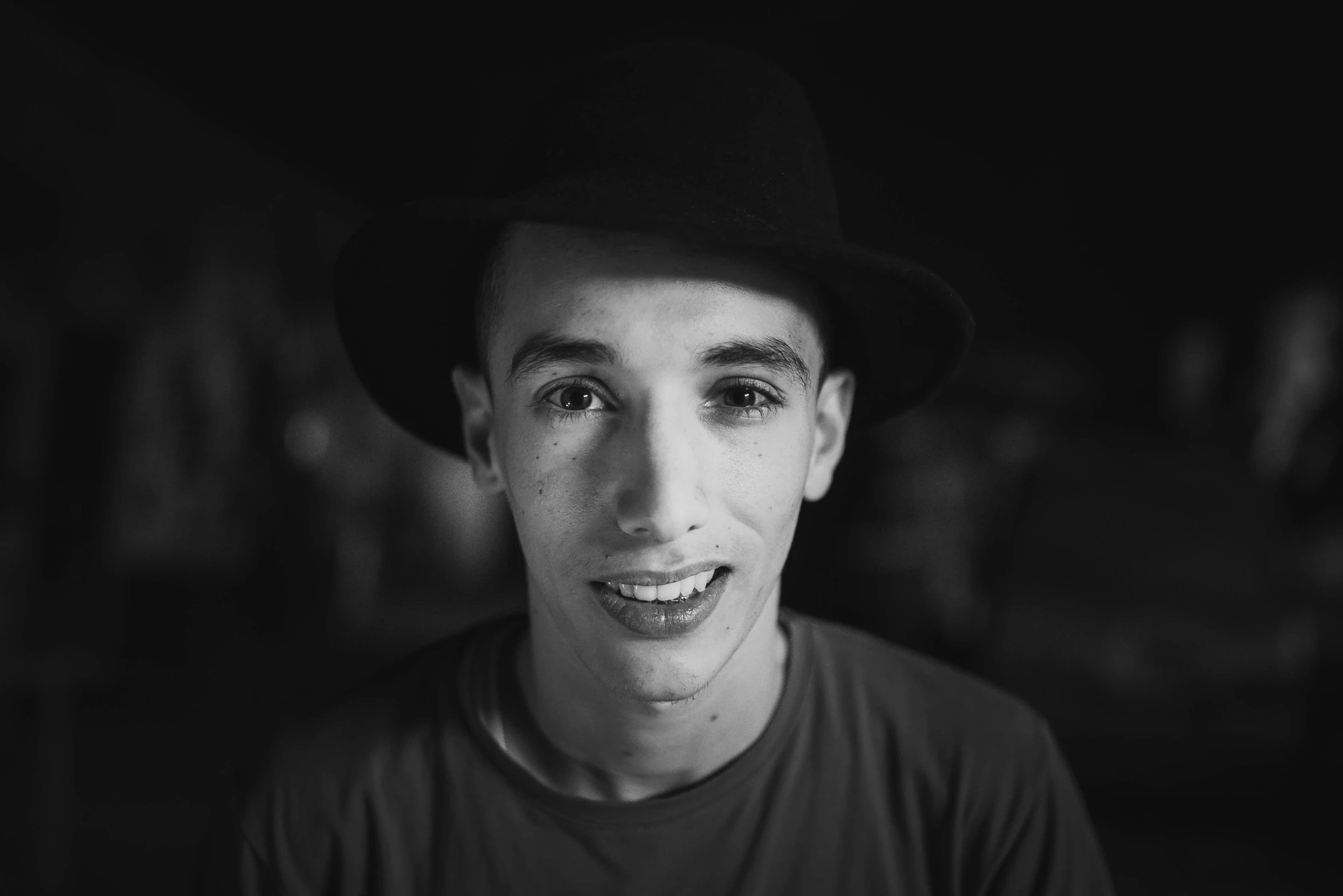 a black and white photo of a man wearing a hat, pexels contest winner, antipodeans, robert sheehan, 14 yo berber boy, 15081959 21121991 01012000 4k, portrait of a smiling