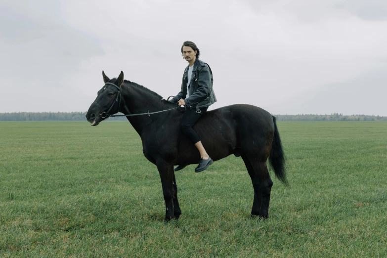 a woman riding on the back of a black horse, an album cover, by Attila Meszlenyi, pexels contest winner, timothee chalamet, aphex twin, countryside, official music video