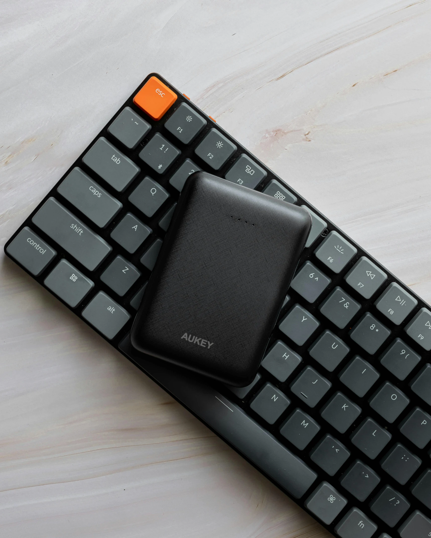 a cell phone sitting on top of a keyboard, audeze, ashy, holding a battery, without duplication