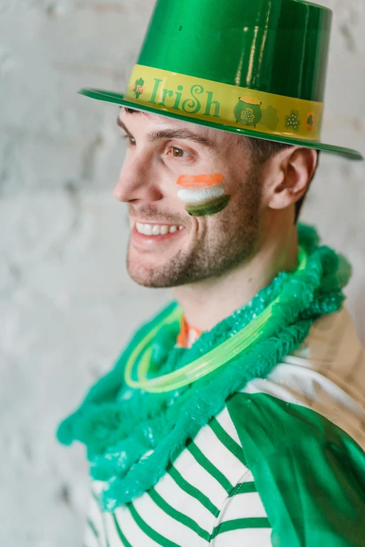 a man wearing a green hat and a green scarf, inspired by Mór Than, pexels contest winner, beer, stripes, christian saint, liam