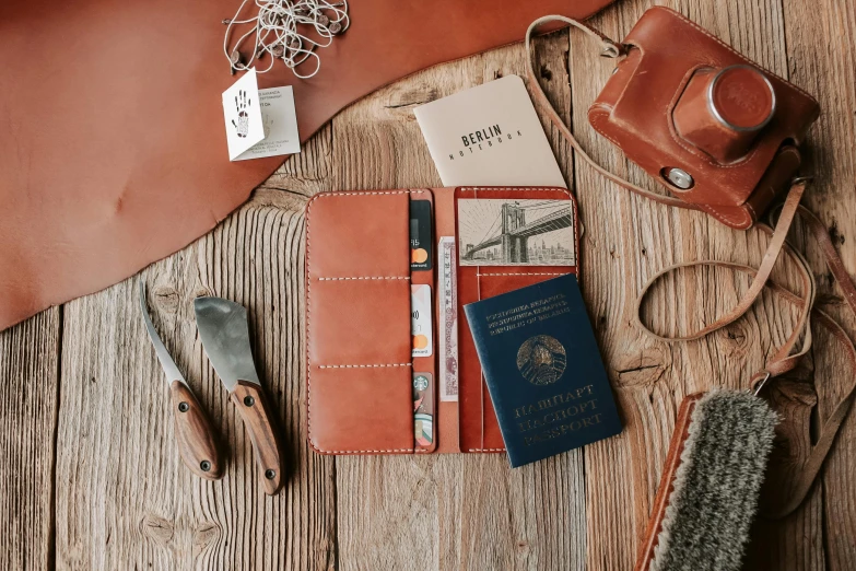 a leather wallet sitting on top of a wooden table, inspired by Wes Anderson, private press, passport, large and tall, assembly instructions, long