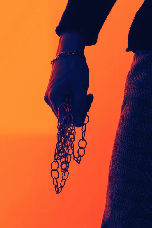 a person holding a chain in their hand, an album cover, inspired by Elsa Bleda, synthetism, ((chains)), vibrant dark mood, dark. no text, promo photo