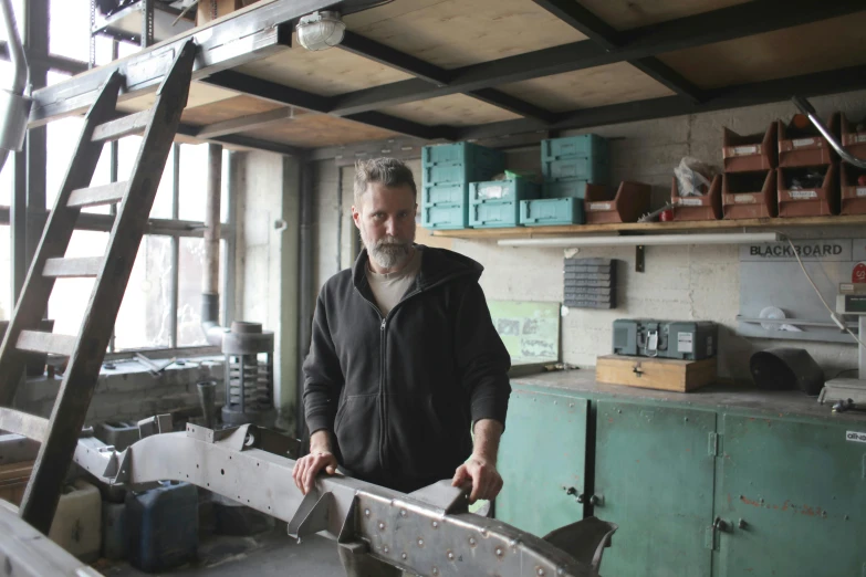 a man standing next to a piece of metal, arbeitsrat für kunst, with mechanical arms that fix it, avatar image