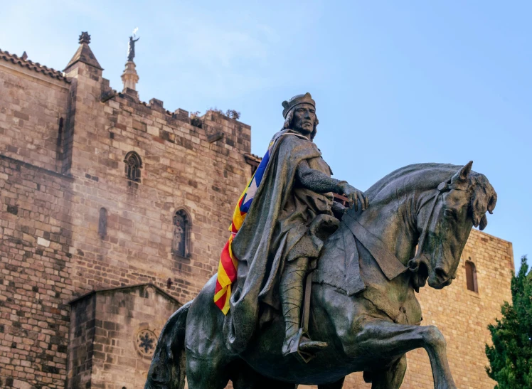 a statue of a man on a horse in front of a castle, a statue, pexels contest winner, romanesque, gothic quarter, wearing a barca cape, bl