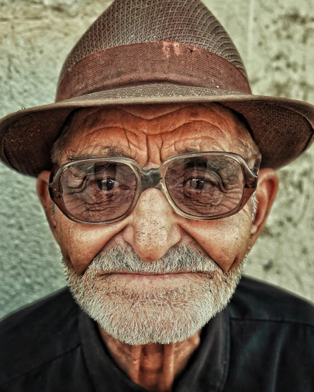 an old man wearing a hat and glasses, a colorized photo, pexels contest winner, weathered olive skin, friendly face, symmetric face, tight shot of subject