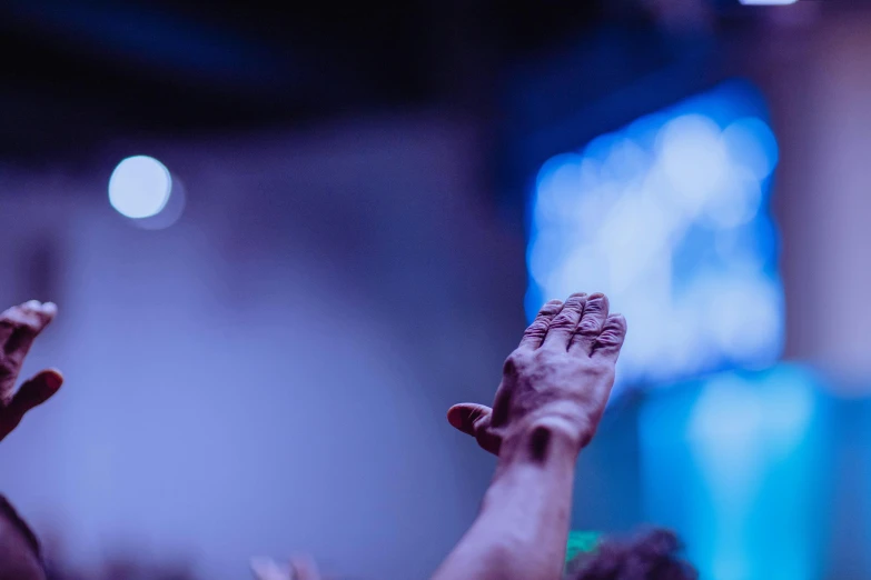 a group of people with their hands in the air, by Daniel Lieske, trending on unsplash, scene from church, blue toned, indistinct man with his hand up, 15081959 21121991 01012000 4k