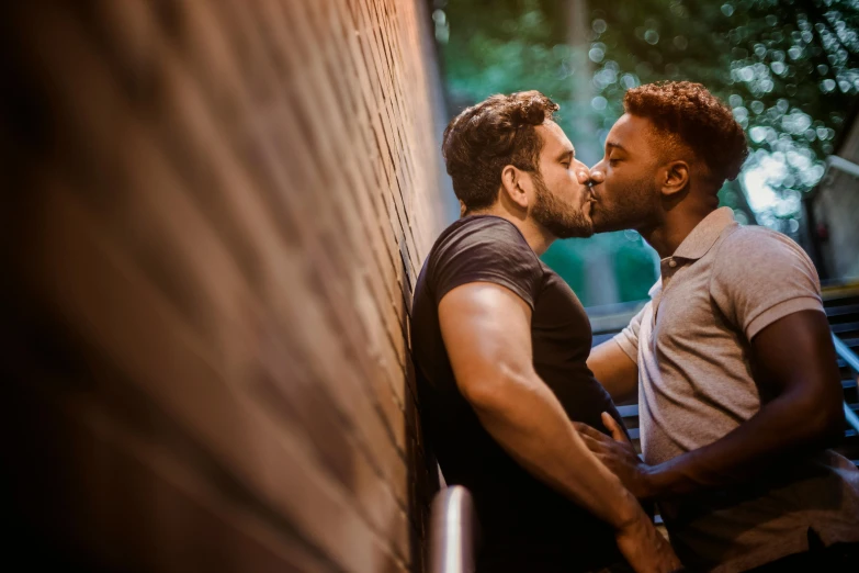 a couple of men standing next to each other, by Joe Bowler, pexels contest winner, renaissance, lesbian kiss, mixed race, promotional image, location [ chicago ( alley ) ]