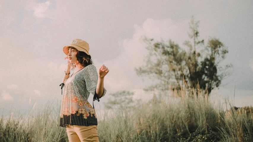 a woman standing in a field talking on a cell phone, pexels contest winner, caracter with brown hat, wearing a blouse, full body:: sunny weather::, joy ang