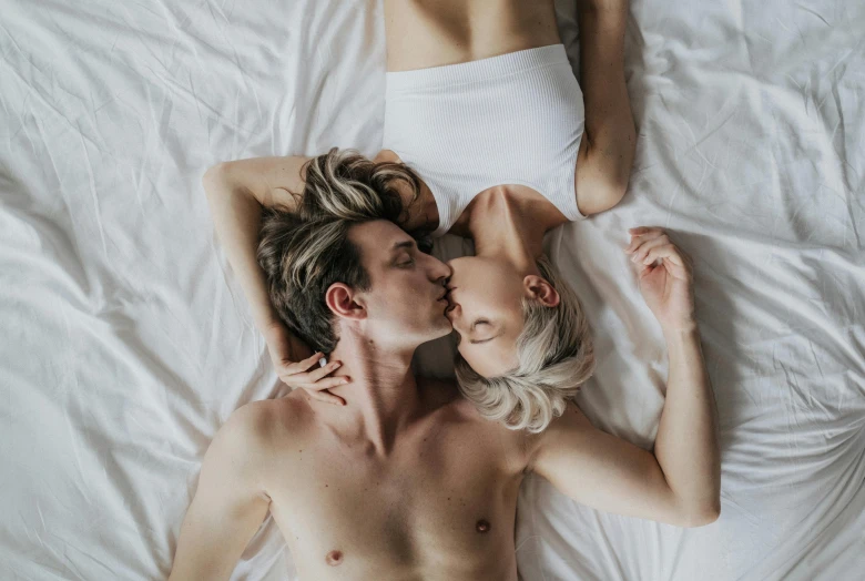 a man and a woman laying on top of a bed, by Jessie Alexandra Dick, trending on pexels, kiss mouth to mouth, lachlan bailey, with a twin, adam and eve