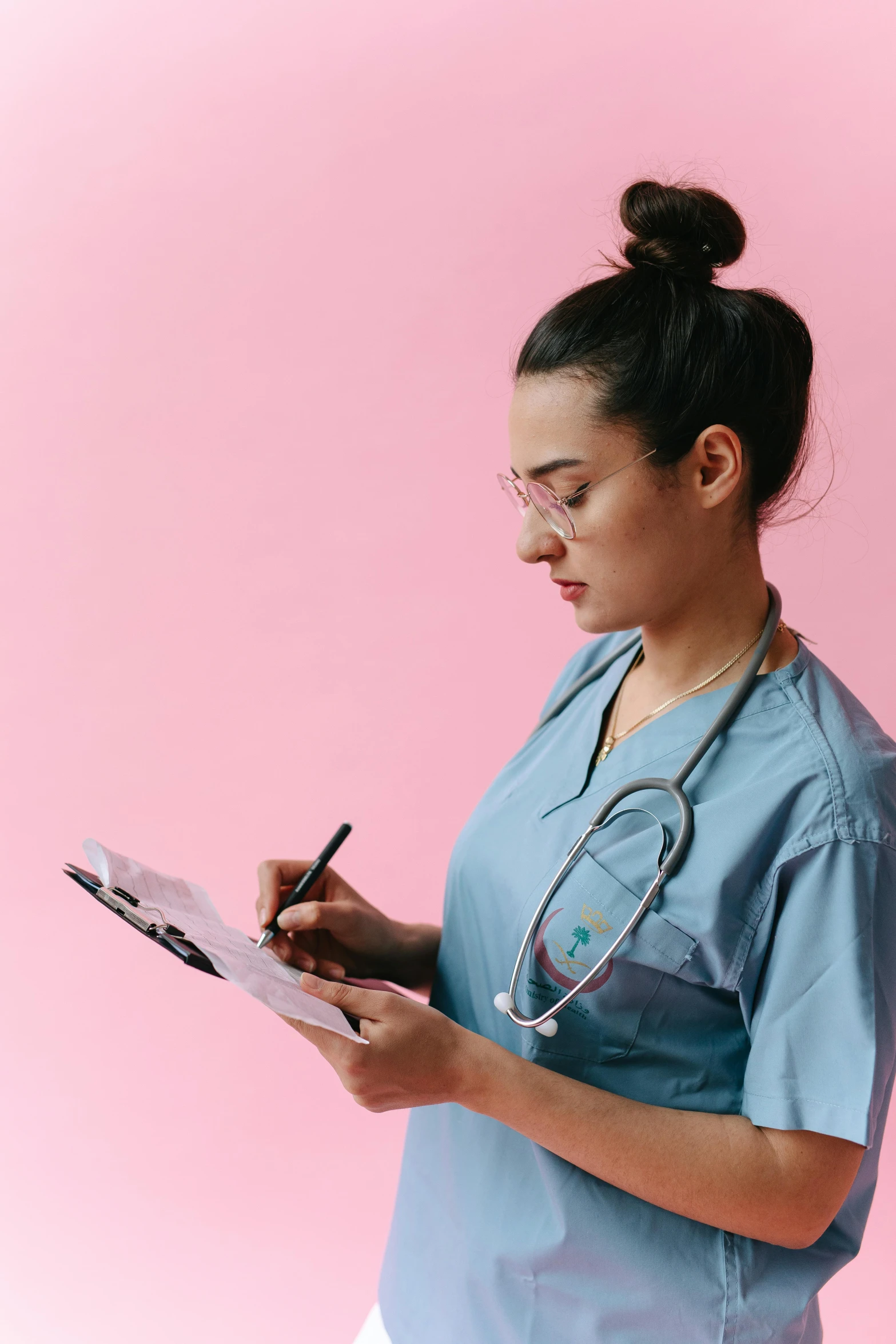 a female nurse writing on a clipboard, by Meredith Dillman, pexels, happening, pink and blue, profile posing, thumbnail, brown