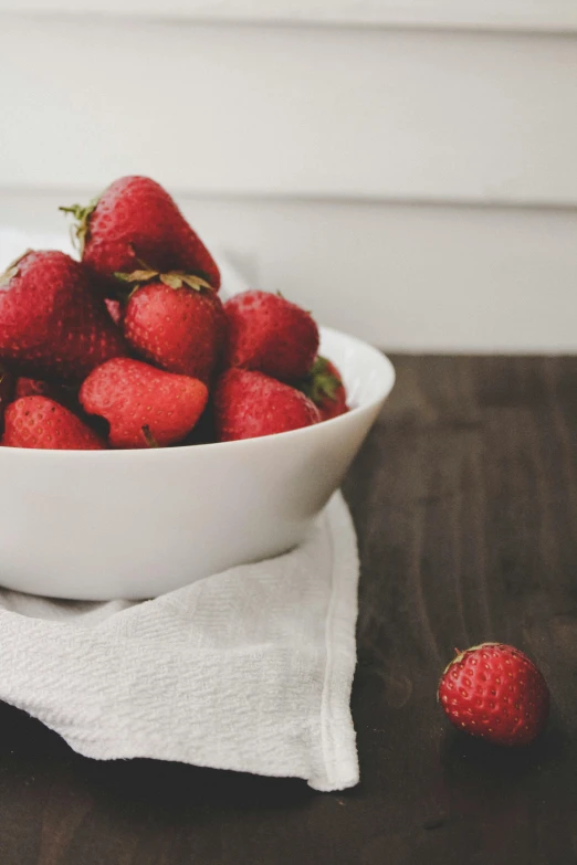 a bowl of strawberries sitting on top of a table, by Kristin Nelson, unsplash, digitally remastered, loosely cropped, linen, smooth matte