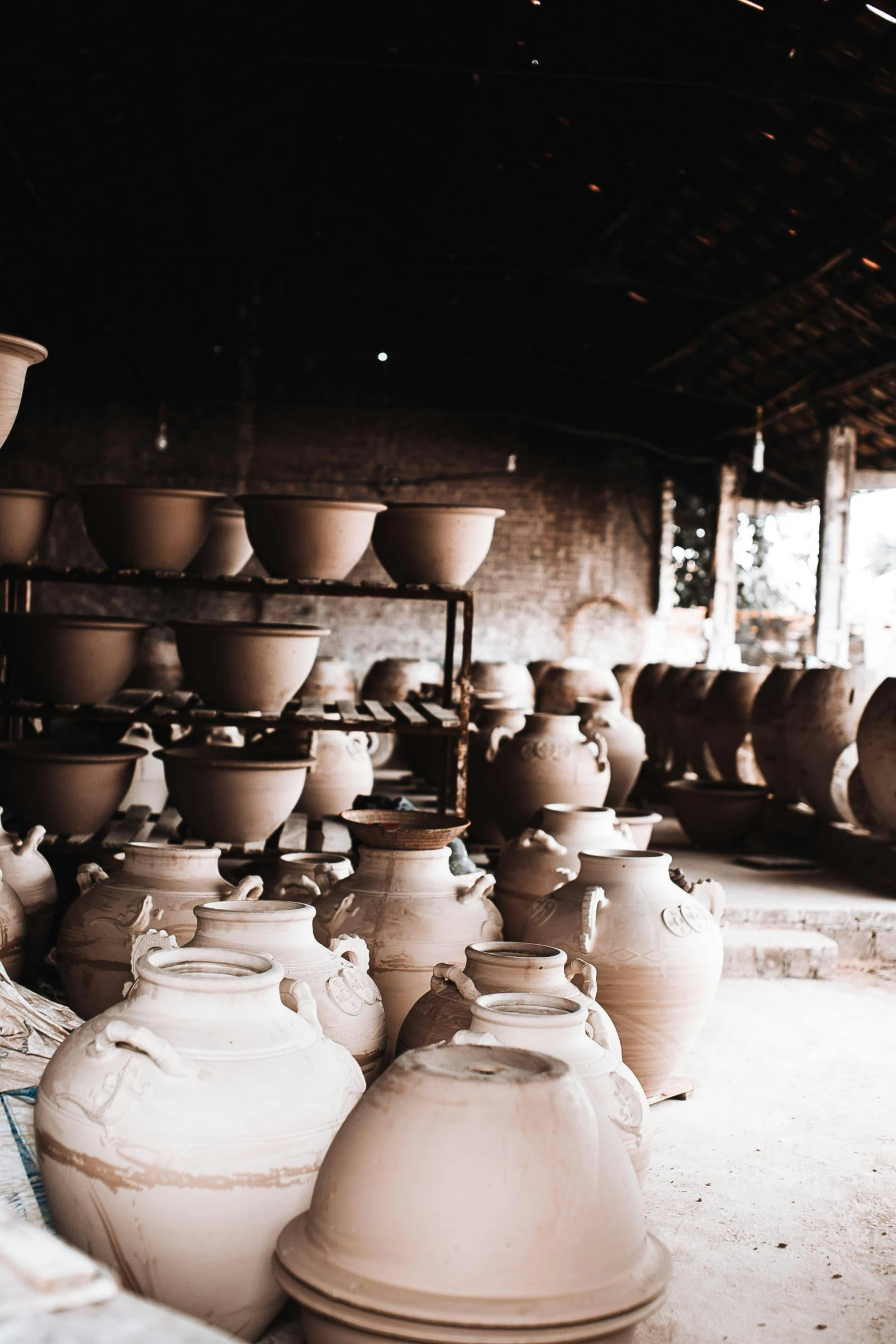 a group of vases sitting on top of a table, lots of building, inside a shed, in style of lam manh, pots and pans