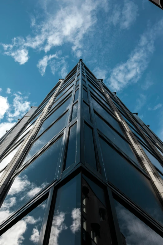 a very tall building with a lot of windows, inspired by Tadao Ando, unsplash, black steel buildings, clear blue skies, high resolution, looking upwards