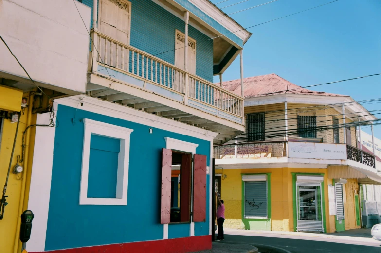 a colorful building on the corner of a street, a photo, by Carey Morris, pexels contest winner, caribbean, brown red blue, slide show, shot on hasselblad