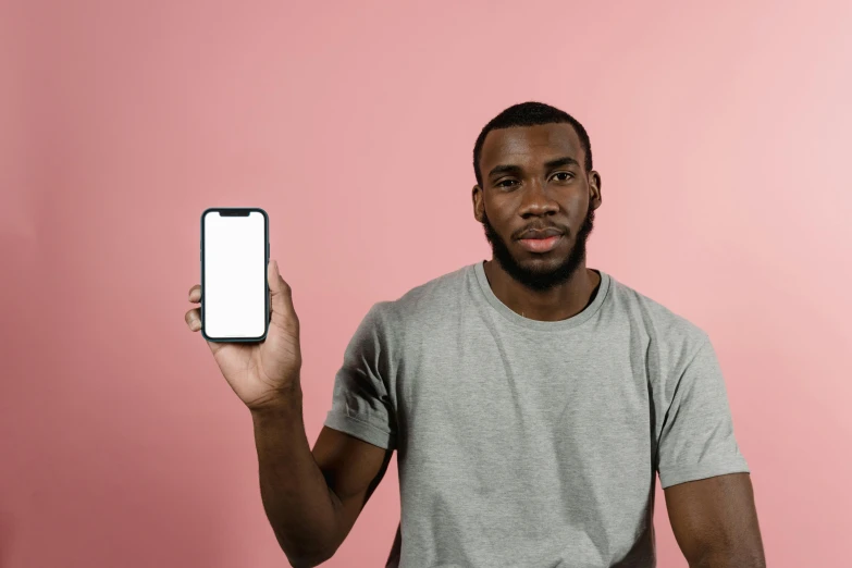 a man holding up a smart phone with a blank screen, by Carey Morris, pexels contest winner, brown skin, iphone 15 background, frontal pose, with a whitish