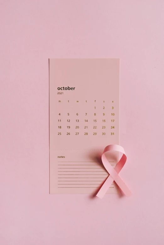 a pink ribbon laying on top of a calendar, by Julia Pishtar, instagram post, october, wholesome, 15081959 21121991 01012000 4k