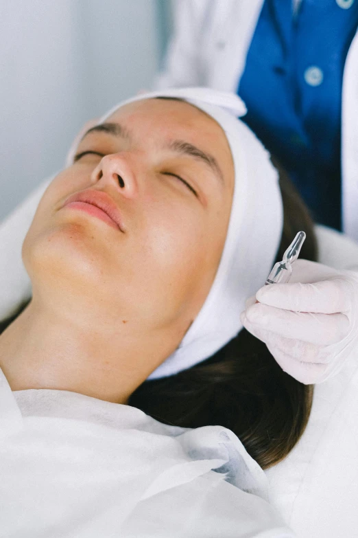 a woman getting an injection from a doctor, a digital rendering, trending on pexels, renaissance, sleepy fashion model face, square nose, lying down, chiseled jawline
