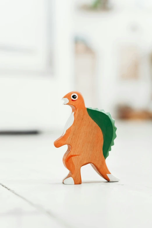 a close up of a toy dinosaur on a floor, inspired by Adam Rex, private press, standing bird, charmander, wooden, hedgehog