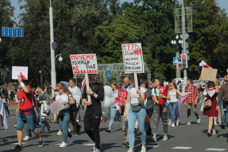 a group of people walking down a street holding signs, a poster, by Anna Katharina Block, shutterstock, russia in 2 0 2 1, against the backdrop of trees, 000 — википедия, parade