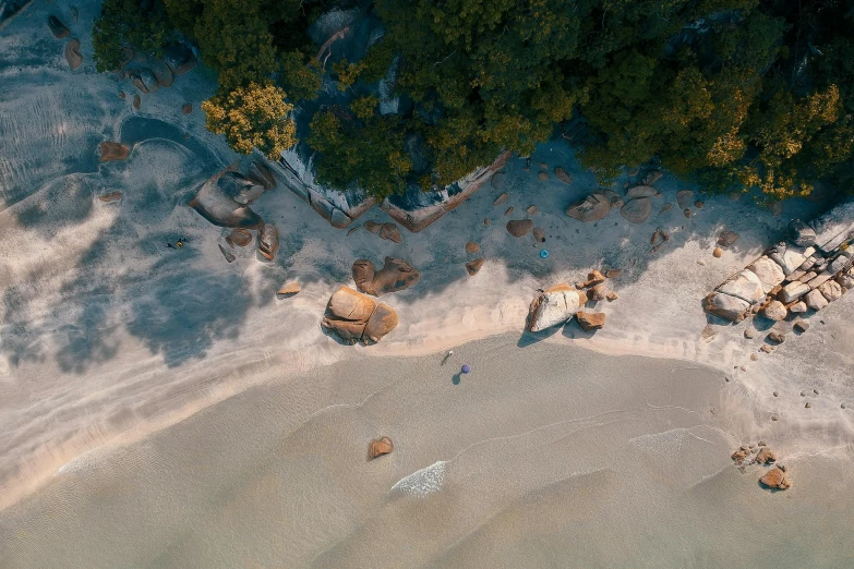 a bird's eye view of a sandy beach, unsplash contest winner, tall big rocks, aussie, lush surroundings, elegant pose