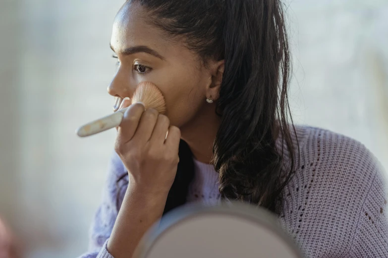 a woman brushing her teeth in front of a mirror, pexels contest winner, hurufiyya, brown skin. light makeup, with a ponytail, summer morning light, white powder makeup