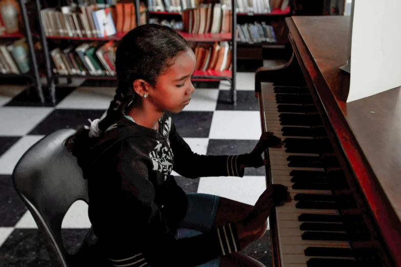 a young girl sitting at a piano in a library, black arts movement, fan favorite, ap photo, improvisational, ignant