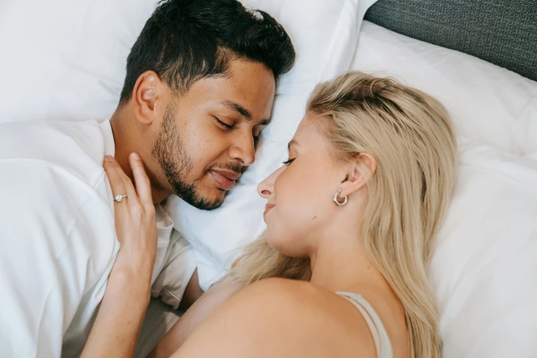 a man and woman laying in bed next to each other, trending on pexels, profile image, background image, mixed race, blonde