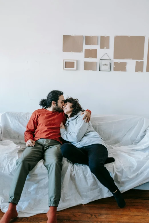 a man and a woman sitting on a couch, pexels contest winner, romanticism, plain background, instagram post, in a comfy house, kiss