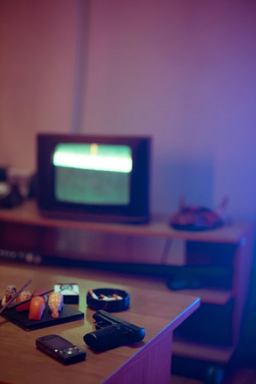 a flat screen tv sitting on top of a wooden desk, an album cover, inspired by Elsa Bleda, late night melancholic photo, playing games, cigarrette boxes at the table, 8 0 s asian neon movie still