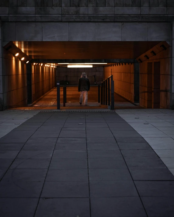 a person standing in a tunnel at night, an album cover, unsplash, brutalism, walkway, non-binary, late morning, ignant