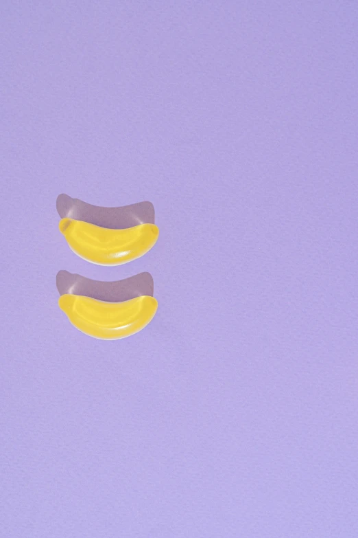 a couple of bananas sitting on top of a purple surface, inspired by Ren Hang, trending on pexels, translucent gills, silicone patch design, cute teeth, half moon