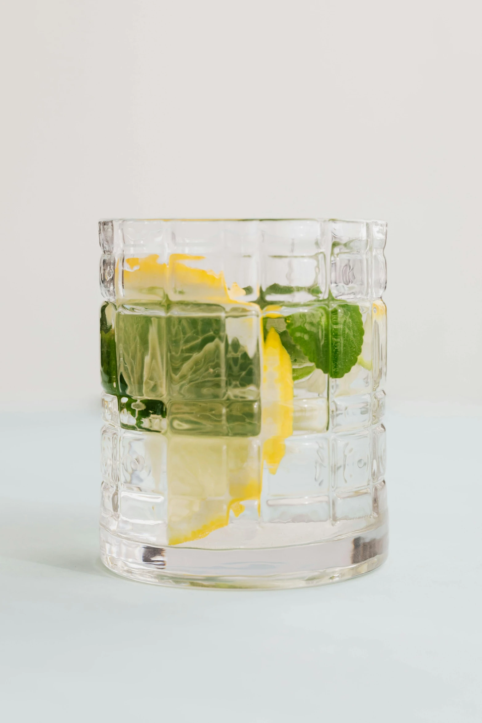 a close up of a glass of water with lemon and mint, by Nina Hamnett, crystal cubism, square glasses, 35 mm product photo”, multi-part, bar