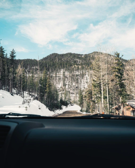 the dashboard of a car on a snowy road, pexels contest winner, solo hiking in mountains trees, clear skies, thumbnail, small town surrounding