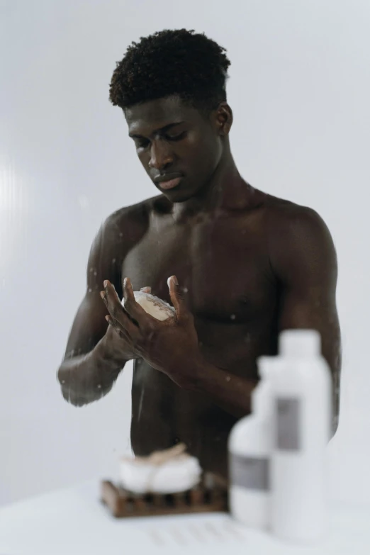 a man that is standing in front of a mirror, ebony skin, partially cupping her hands, dry brushing, showers