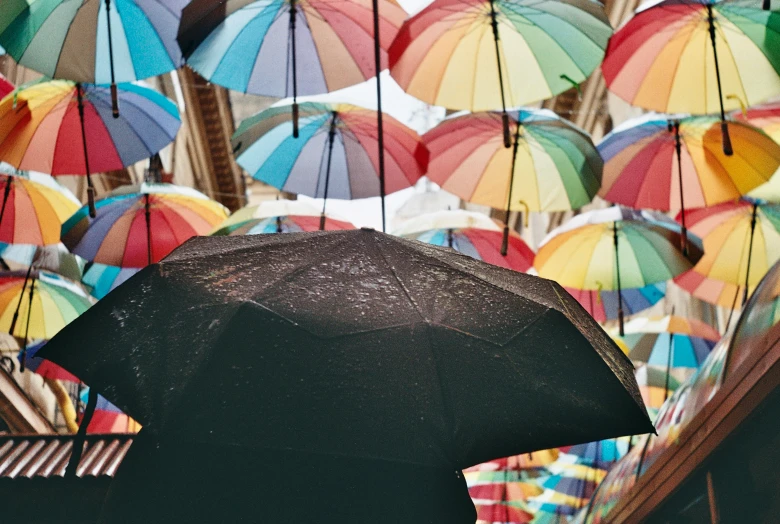 there are many colorful umbrellas hanging from the ceiling, unsplash contest winner, hyperrealism, black umbrella, lo fi colors, instagram post, on a bright day