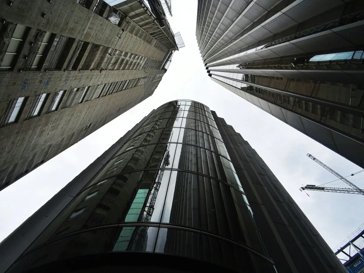 a group of tall buildings next to each other, by Dave Allsop, pexels contest winner, low angle fisheye view, te pae, seen from outside, ominous