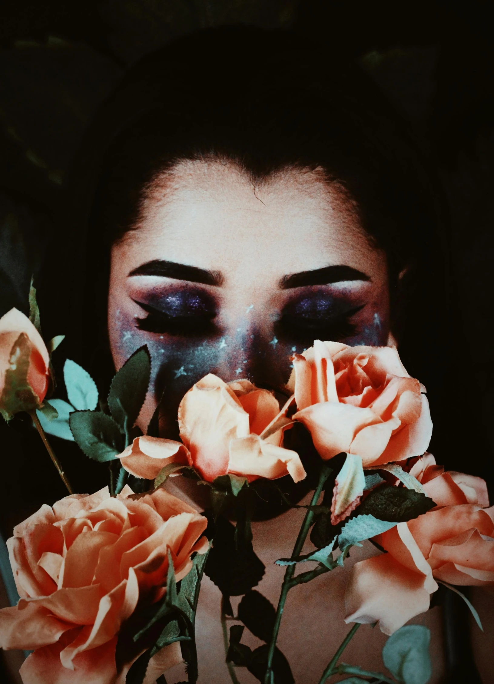 a woman holding a bunch of flowers in front of her face, an album cover, inspired by Elsa Bleda, trending on unsplash, aestheticism, dark glitter makeup, ☁🌪🌙👩🏾, exploding roses, galaxy eyes