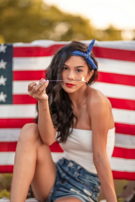 a woman sitting on the ground in front of an american flag, a portrait, pexels contest winner, soft devil queen madison beer, brushes her teeth, uncle sam, handsome girl